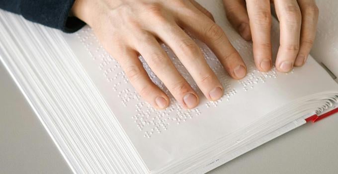 person reading using braille