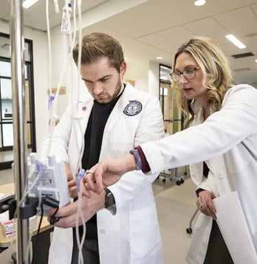 Amber Bugajski, MSN RN CHSE, (right) explains a procedure to a Pitt-Greensburg Nursing student.